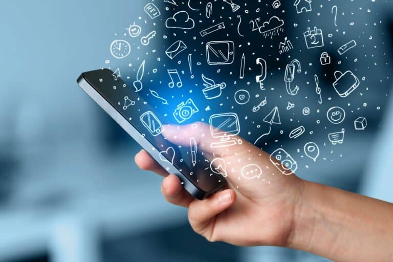 Hand holding smartphone with hand drawn media icons and symbols